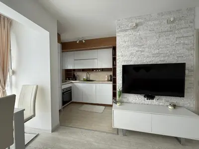 a kitchen with a flat screen tv on a brick wall at Apartman Marija sa ličnim đakuzijem in Becici