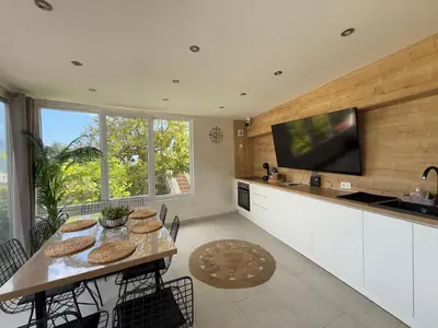 a kitchen with a table with chairs and a tv at Apartman Marija sa ličnim đakuzijem in Becici