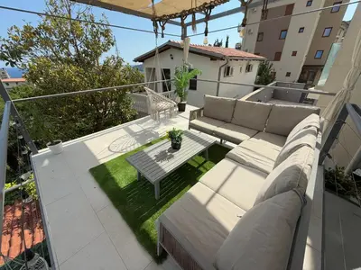 a patio with a couch and a table on a balcony at Apartman Marija sa ličnim đakuzijem in Becici