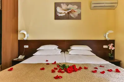 two beds with red roses on the bed at Hotel Premier in Budva