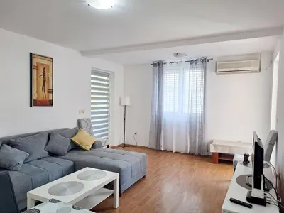 a living room with a blue couch and a tv at Apartment Butua. in Budva