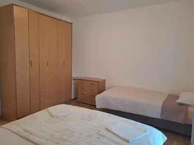 a small bedroom with two beds and a dresser at Apartment Butua. in Budva