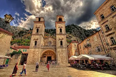 a group of people walking in front of a church at Apartment Butua. in Budva