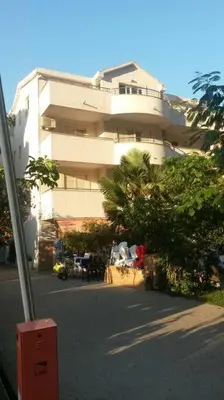 a building with a parking lot in front of it at Apartment Butua. in Budva