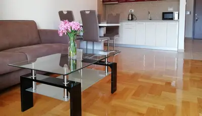 a living room with a glass table with flowers on it at Apartment Anatolia of Becici in Becici
