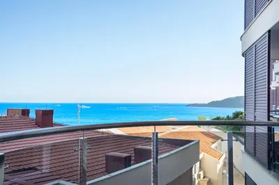 a view of the ocean from the balcony of a building at Apartment Anatolia of Becici in Becici