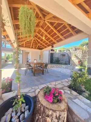 a patio with a table and some flowers at Sunny Side Apartments in Rijeka Crnojevića
