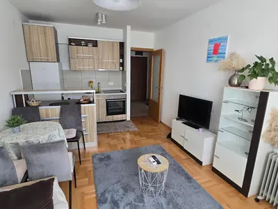 a living room with a table and a kitchen at LaMar in Budva