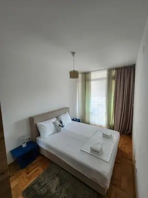 a bedroom with a large white bed with a window at LaMar in Budva