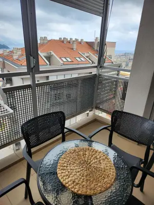a balcony with a table and two chairs and a window at LaMar in Budva