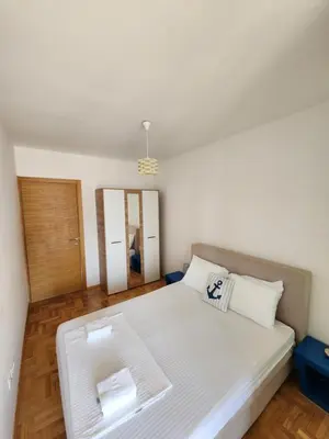 a bedroom with a large white bed and a mirror at LaMar in Budva