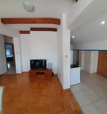 a living room with a tv and a wooden floor at Apartman Bravo Budva in Budva