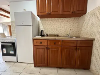 a kitchen with a white refrigerator and a sink at Apartman Bravo Budva in Budva