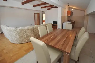 a kitchen and dining room with a wooden table and chairs at Apartman Bravo Budva in Budva