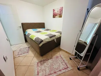 a small bedroom with a bed and a mirror at Podgorica city center apartment in Podgorica