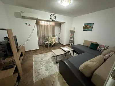 a living room with a couch and a clock on the wall at Podgorica city center apartment in Podgorica