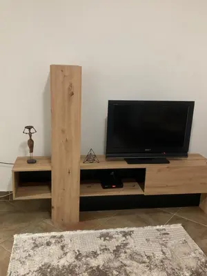a wooden entertainment center with a flat screen tv at Podgorica city center apartment in Podgorica