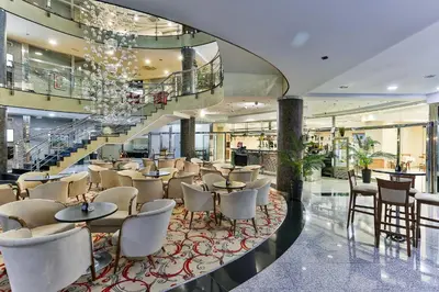 a restaurant with tables and chairs in a building at Kings Park Hotel in Podgorica