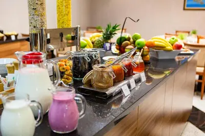 a counter with a bunch of food and drinks on it at Kings Park Hotel in Podgorica