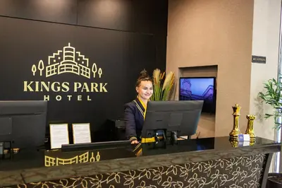 a woman standing at a desk in a kings park hotel at Kings Park Hotel in Podgorica