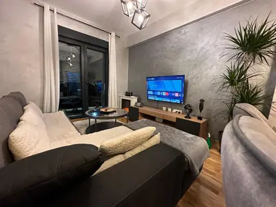 a living room with a couch and a flat screen tv at Arbo LUX Apartment in Podgorica