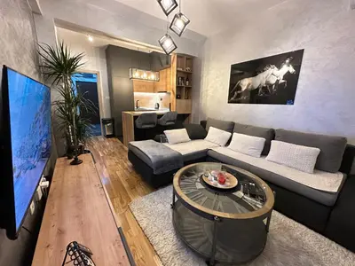 a living room with a couch and a tv at Arbo LUX Apartment in Podgorica
