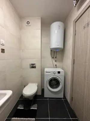 a bathroom with a toilet and a washing machine at Arbo LUX Apartment in Podgorica