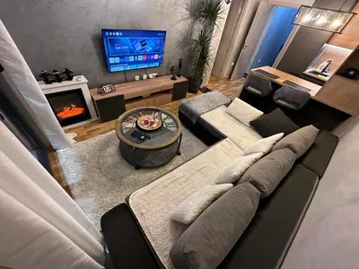 a living room with a couch and a tv at Arbo LUX Apartment in Podgorica