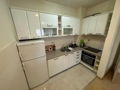 a kitchen with white cabinets and a white refrigerator at Hanna apatment in Podgorica