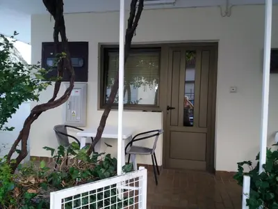a table and chairs in front of a house at Apartman - Sutomore in Sutomore