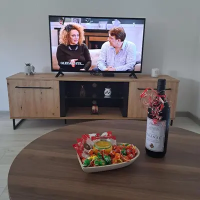 a table with a television and a plate of food at Knežević apartman in Podgorica