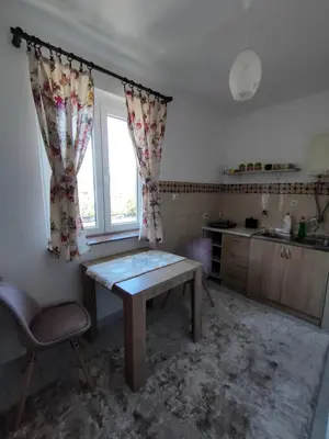 a kitchen with a wooden table and a window at Lepa Kata Centar in Podgorica