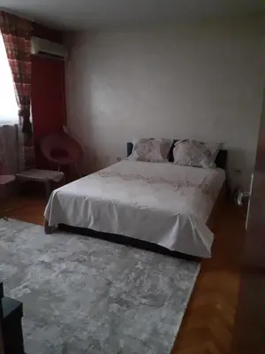 a bedroom with a white bed and a rug at Lepa Kata Centar in Podgorica