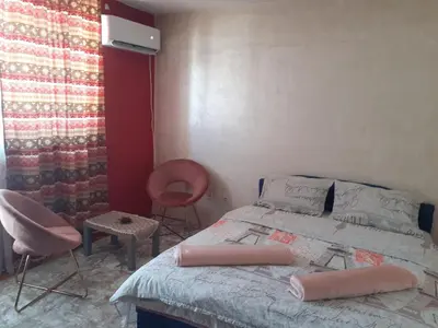 a bedroom with a bed and a chair and a window at Lepa Kata Centar in Podgorica