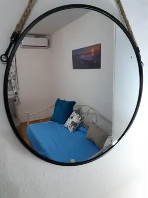 a mirror reflection of a bed in a room at Apartman Paris in Podgorica