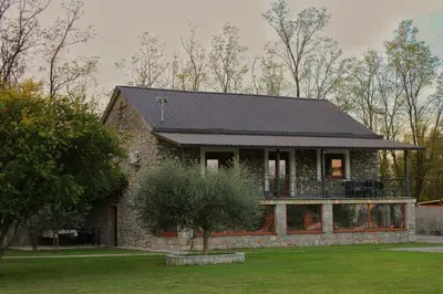 a stone house with a black roof at Konoba Stanisic in Balabani