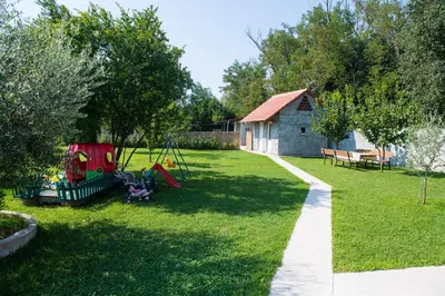 a yard with a playground and a house at Konoba Stanisic in Balabani