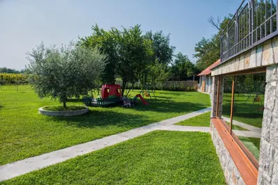 a yard with a tree and a building at Konoba Stanisic in Balabani