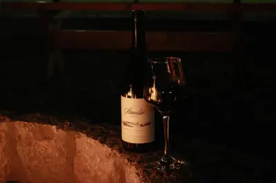a bottle of wine sitting next to a wine glass at Konoba Stanisic in Balabani