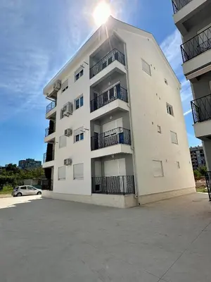 a white apartment building with a car parked in front at Stex Urban 2 in Podgorica