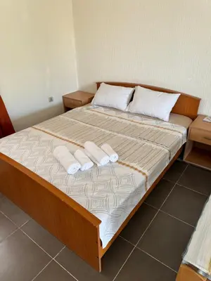 a bed with two pillows on it in a room at Apartments Airport Golubovci in Podgorica