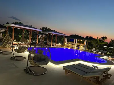 a swimming pool with a swing and a playground at Villa 100 Palme in Ulcinj