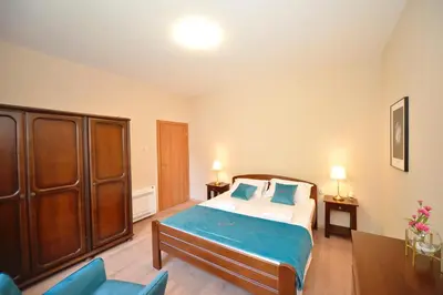 a bedroom with a large bed and blue chairs at Fjordfront Aerie in Kotor