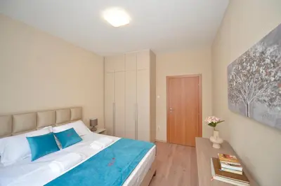 a bedroom with a large bed with blue pillows at Fjordfront Aerie in Kotor