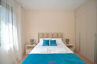 a bedroom with a large bed with blue pillows at Fjordfront Aerie in Kotor