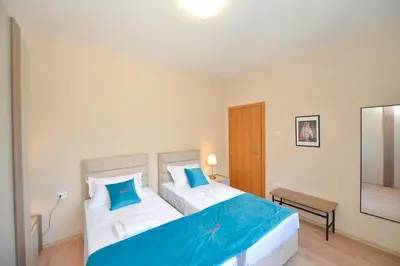 a bedroom with two beds with blue pillows at Fjordfront Aerie in Kotor