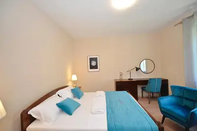 a bedroom with a bed and a chair and a desk at Fjordfront Aerie in Kotor