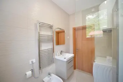 a white bathroom with a sink and a toilet at Fjordfront Aerie in Kotor