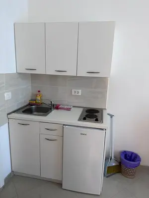 a small kitchen with white cabinets and a sink at Apartments Blanco in Budva