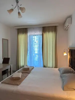 a bedroom with a large bed with a window at Apartments Blanco in Budva